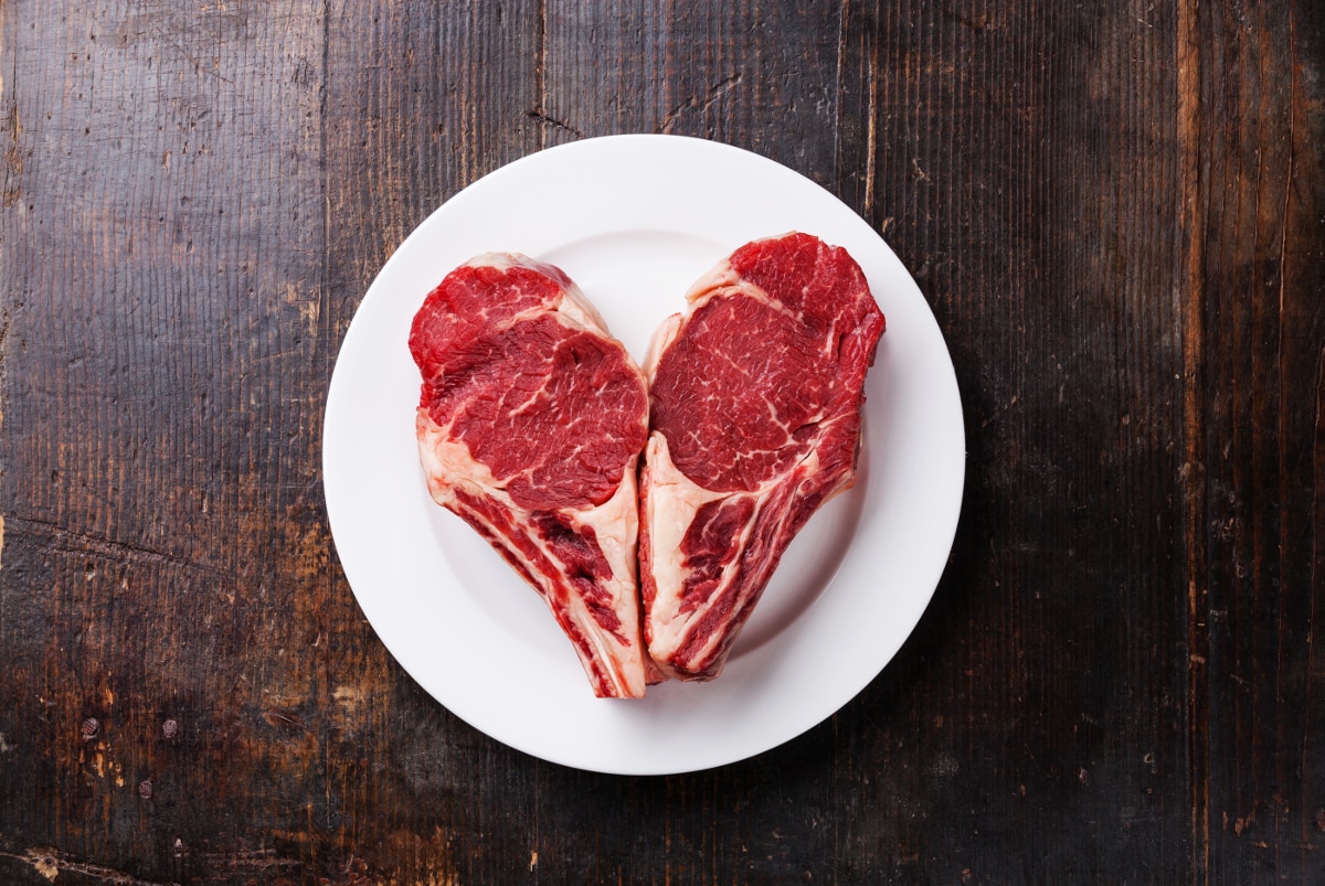 Heart shape Raw meat Ribeye steak entrecote on white plate