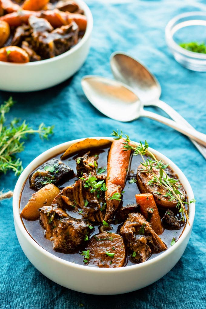 This slow cooker gluten-free beef bourguignon (or Beef Burgundy) recipe is the best I have ever tried. Cooking it in a slow cooker makes it super easy to prepare and extra tasty! My very simple version of this classic French stew is entirely gluten-free and can be made paleo by picking the right red wine for this particular diet. | www.onecleverchef.com #paleo #gluten-free #comfortfood #stew #beefbourguignon #slowcooker #healthy #weeknight #crockpot