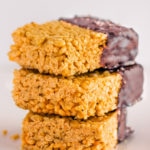 These healthy & no-bake vegan rice crispy treats are made with only 3 ingredients: peanut butter, maple syrup, and crispy rice cereal. No marshmallow here. Protein powder and chocolate topping are optional. This easy, clean eating snack can be whipped together in less than 10 minutes and is TOTALLY kid approved! :) | onecleverchef.com #glutenfree #dairyfree #veganprotein #proteinsnack #family #fun