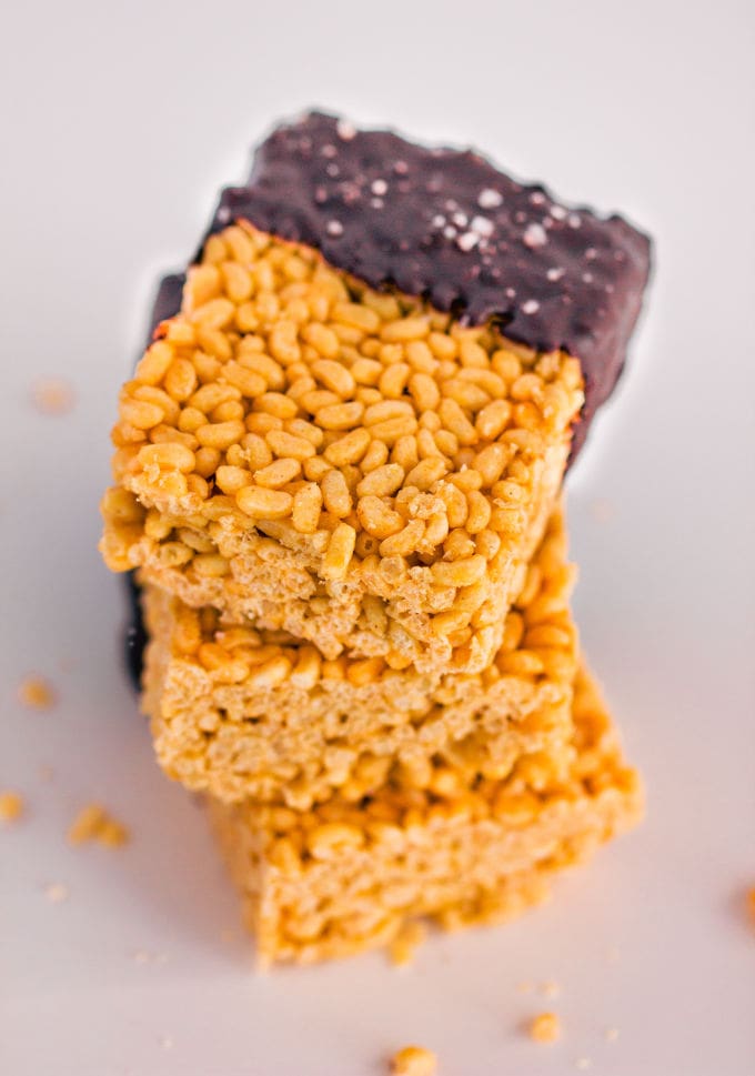 These healthy & no-bake vegan rice crispy treats are made with only 3 ingredients: peanut butter, maple syrup, and crispy rice cereal. No marshmallow here. Protein powder and chocolate topping are optional. This easy, clean eating snack can be whipped together in less than 10 minutes and is TOTALLY kid approved! :) | onecleverchef.com #glutenfree #dairyfree #veganprotein #proteinsnack #family #fun 