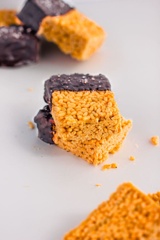 These healthy & no-bake vegan rice crispy treats are made with only 3 ingredients: peanut butter, maple syrup, and crispy rice cereal. No marshmallow here. Protein powder and chocolate topping are optional. This easy, clean eating snack can be whipped together in less than 10 minutes and is TOTALLY kid approved! :) | onecleverchef.com #glutenfree #dairyfree #veganprotein #proteinsnack #family #fun 