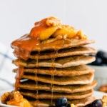 These healthy & fluffy vegan buckwheat pancakes are very easy to make. Only 4 ingredients, no eggs, dairy-free and gluten-free, these are topped with caramelized banana slices, blueberries, a peanut butter caramel coulis, walnuts and maple syrup for a sweet & savory breakfast. | onecleverchef.com #onecleverchef #breakfast #vegan #glutenfree