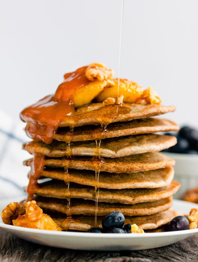 These healthy & fluffy vegan buckwheat pancakes are very easy to make. Only 4 ingredients, no eggs, dairy-free and gluten-free, these are topped with caramelized banana slices, blueberries, a peanut butter caramel coulis, walnuts and maple syrup for a sweet & savory breakfast. | onecleverchef.com #onecleverchef #breakfast #vegan #glutenfree 