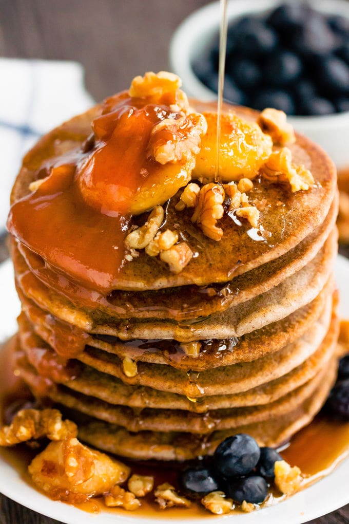 These healthy & fluffy vegan buckwheat pancakes are very easy to make. Only 4 ingredients, no eggs, dairy-free and gluten-free, these are topped with caramelized banana slices, blueberries, a peanut butter caramel coulis, walnuts and maple syrup for a sweet & savory breakfast. | onecleverchef.com #onecleverchef #breakfast #vegan #glutenfree 