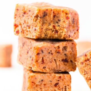 3 peanut butter fudges piled up on top of each other, the upper one has a bite taken from it.