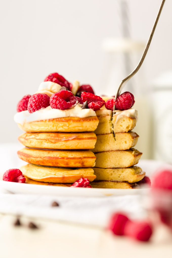 A stack of pancakes with a fork planted in.